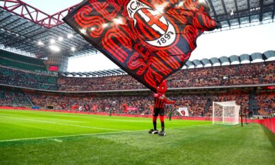 Mascotte Milanello con bandiera rossonera sul campo di San Siro durante una partita del Milan