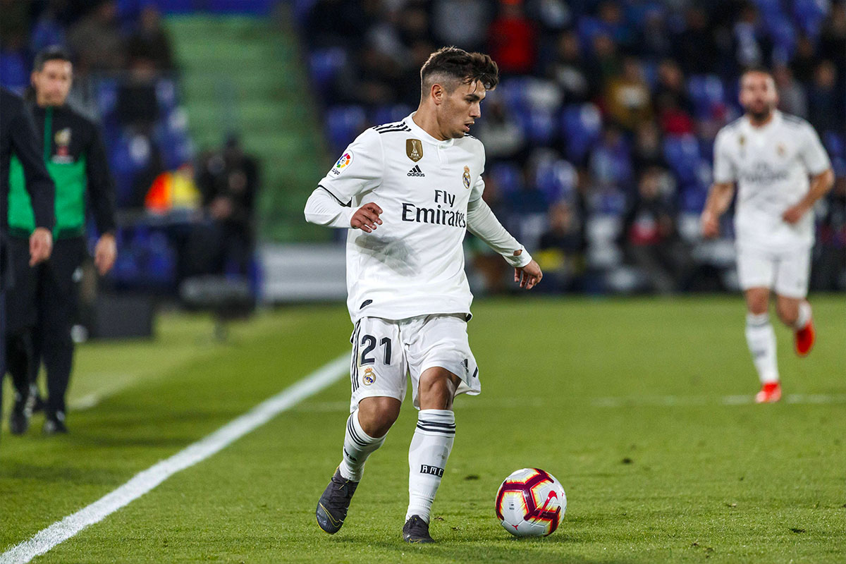 Brahim Diaz con la maglia del Real Madrid controlla il pallone durante una partita