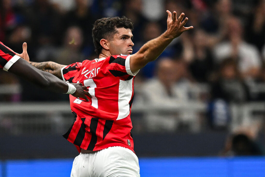 Pulisic del Milan esulta a braccia larghe dopo un gol, con la maglia numero 11
