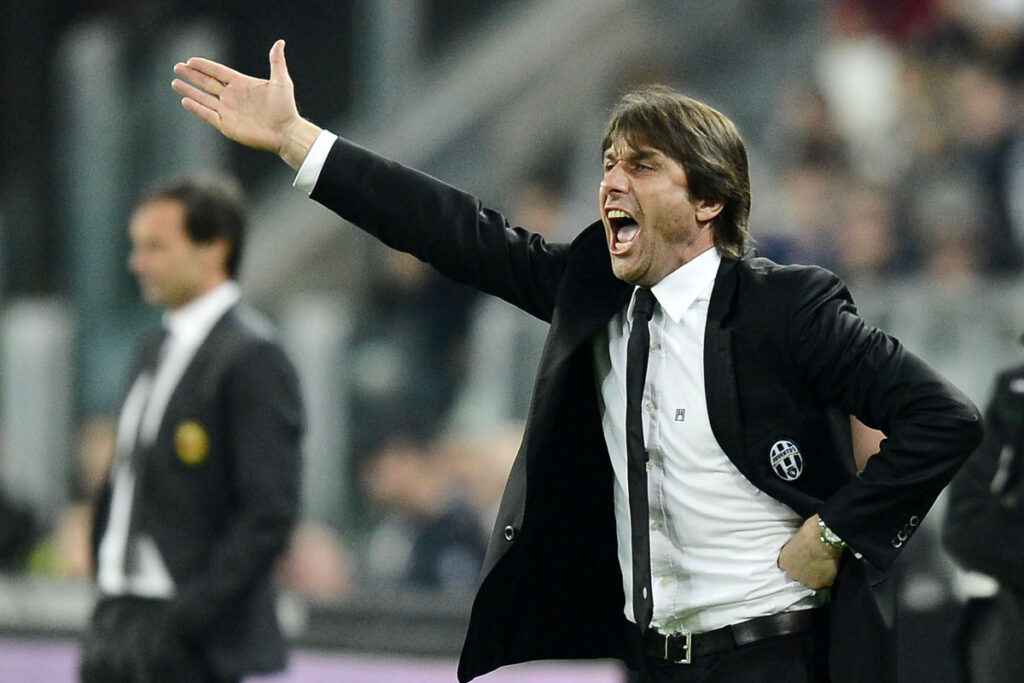Antonio Conte sulla panchina della Juventus dà indicazioni, mentre Allegri osserva da quella del Milan