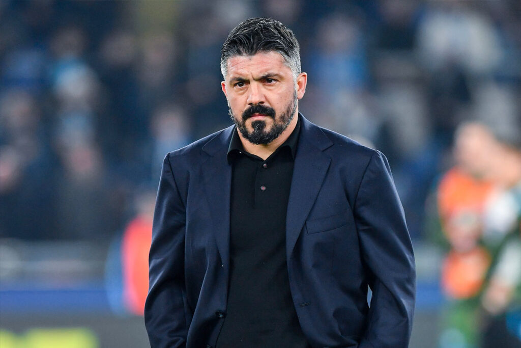Gennaro Gattuso in abito scuro cammina in campo da allenatore del Napoli