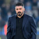 Gennaro Gattuso in abito scuro cammina in campo da allenatore del Napoli