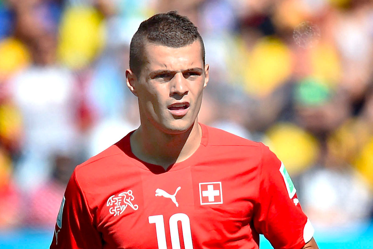 Granit Xhaka in campo con la divisa rossa della Svizzera durante una partita di calcio