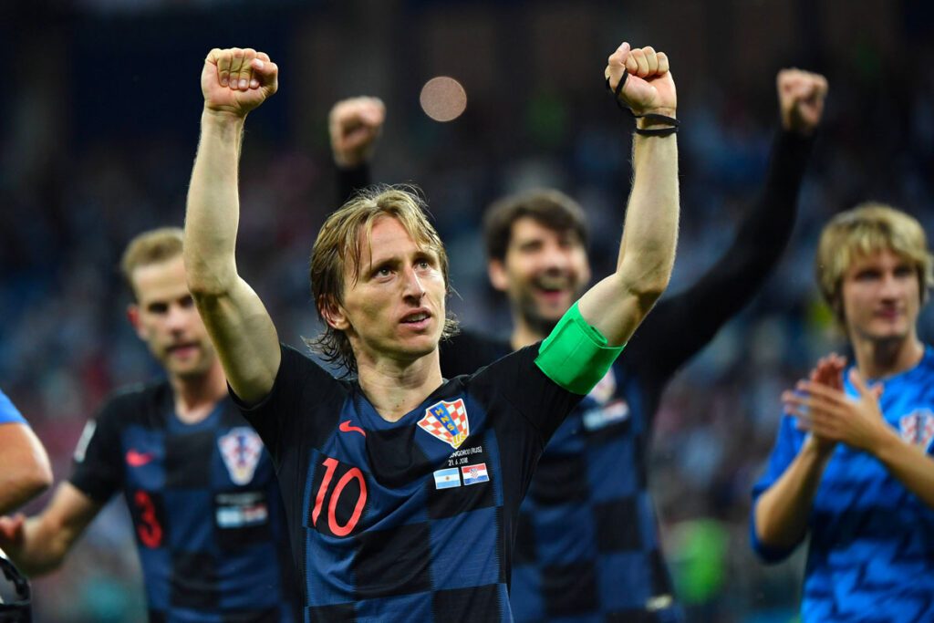 Luka Modric esulta con la Croazia ai Mondiali 2018, compagni sfocati sullo sfondo