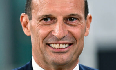 Massimiliano Allegri sorride mentre si sistema la cravatta durante la sua esperienza da allenatore della Juventus