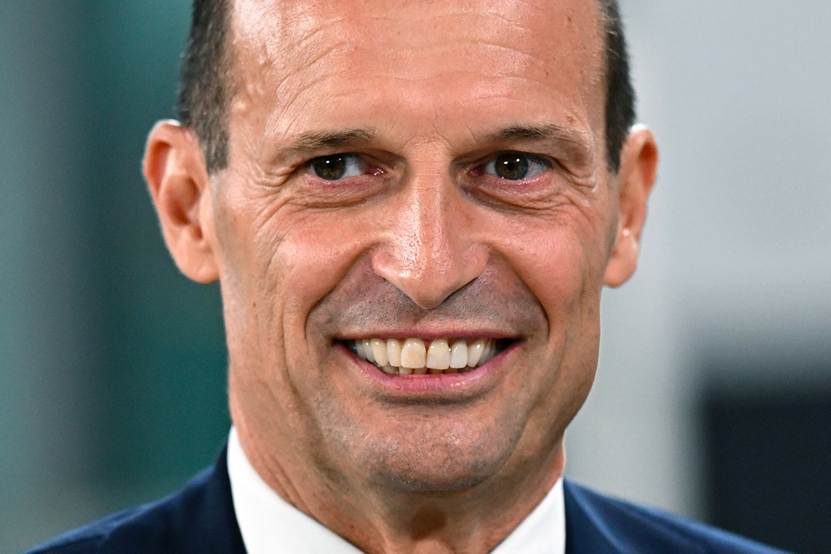 Massimiliano Allegri sorride mentre si sistema la cravatta durante la sua esperienza da allenatore della Juventus