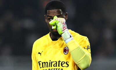 Maignan con la maglia del Milan si tocca il naso con i guantoni in segno di frustrazione durante una partita
