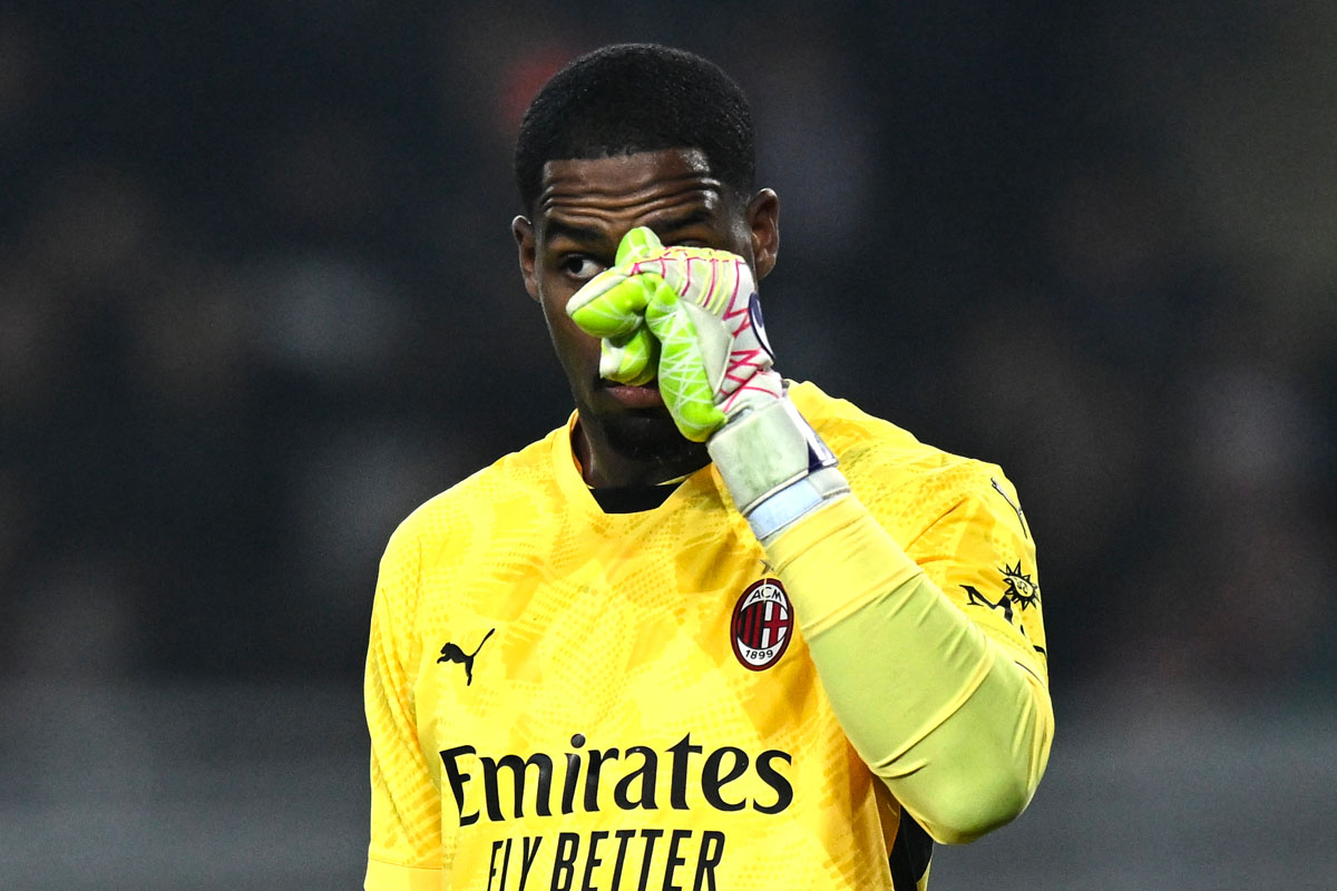 Maignan con la maglia del Milan si tocca il naso con i guantoni in segno di frustrazione durante una partita