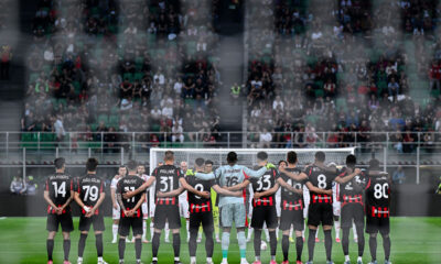 Giocatori del Milan 2024/2025 schierati a centrocampo durante un minuto di silenzio a San Siro prima di una partita di campionato