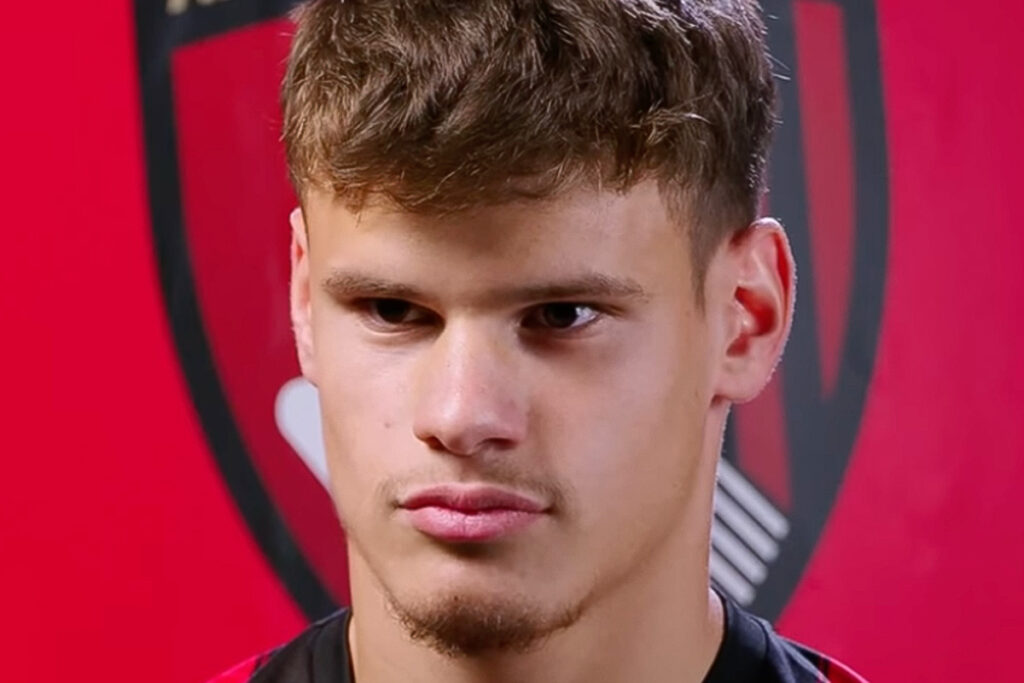 Milos Kerkez in primo piano mentre parla ai media ufficiali del Bournemouth FC