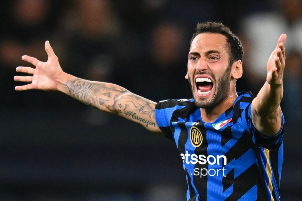 Hakan Calhanoglu allarga le braccia e urla in segno di protesta durante una partita dell’Inter