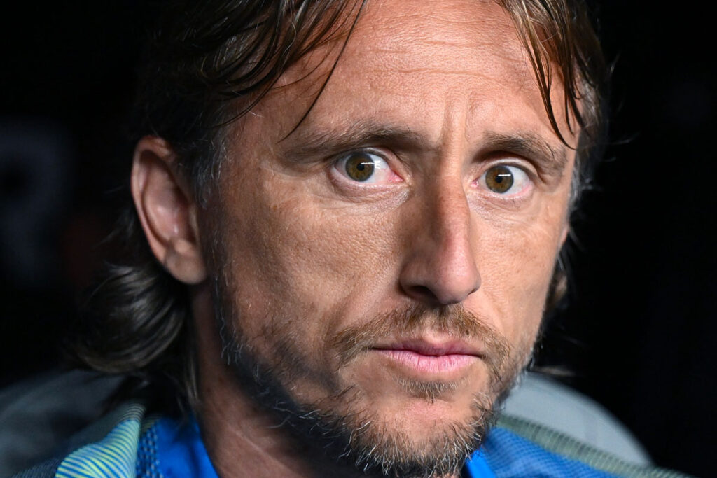 Luka Modrić con sguardo intenso e ravvicinato in panchina durante una delle sue ultime presenze con il Real Madrid