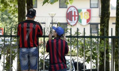Tifosi del Milan, papà e figlio con maglia di Shevchenko, osservano Milanello da dietro la cancellata