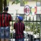 Tifosi del Milan, papà e figlio con maglia di Shevchenko, osservano Milanello da dietro la cancellata