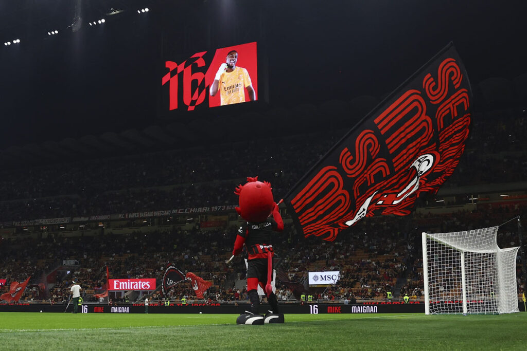 San Siro pre partita Milan con mascotte Milanello che sventola bandierone rossonero sul campo
