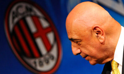 Adriano Galliani di profilo in primo piano con il logo del Milan sfocato alle spalle