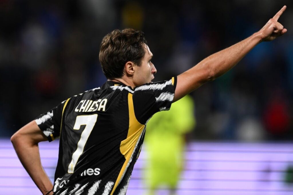 Federico Chiesa esulta con la Juventus dopo un gol con braccio teso e dito puntato in alt