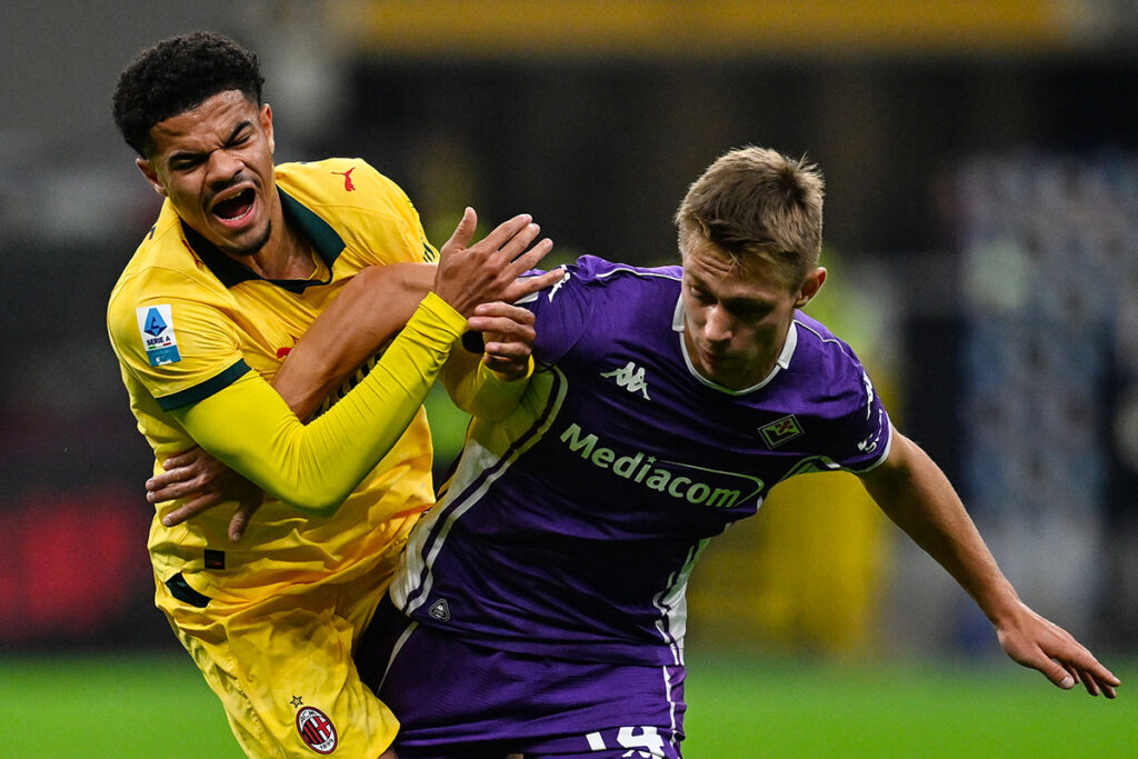 Contrasto tra Athekame del Milan e Nicolussi Caviglia della Fiorentina durante la partita a San Siro.