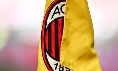 Bandierina gialla del calcio d’angolo a San Siro con logo del Milan in primo piano